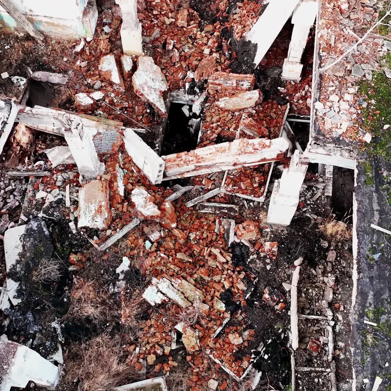 Collapsed ruins of the old building. Bricks, stones and pieces of concrete left after the house bombing. Aerial view