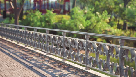 a decorative railing along a scenic path in a vibrant park during daytime