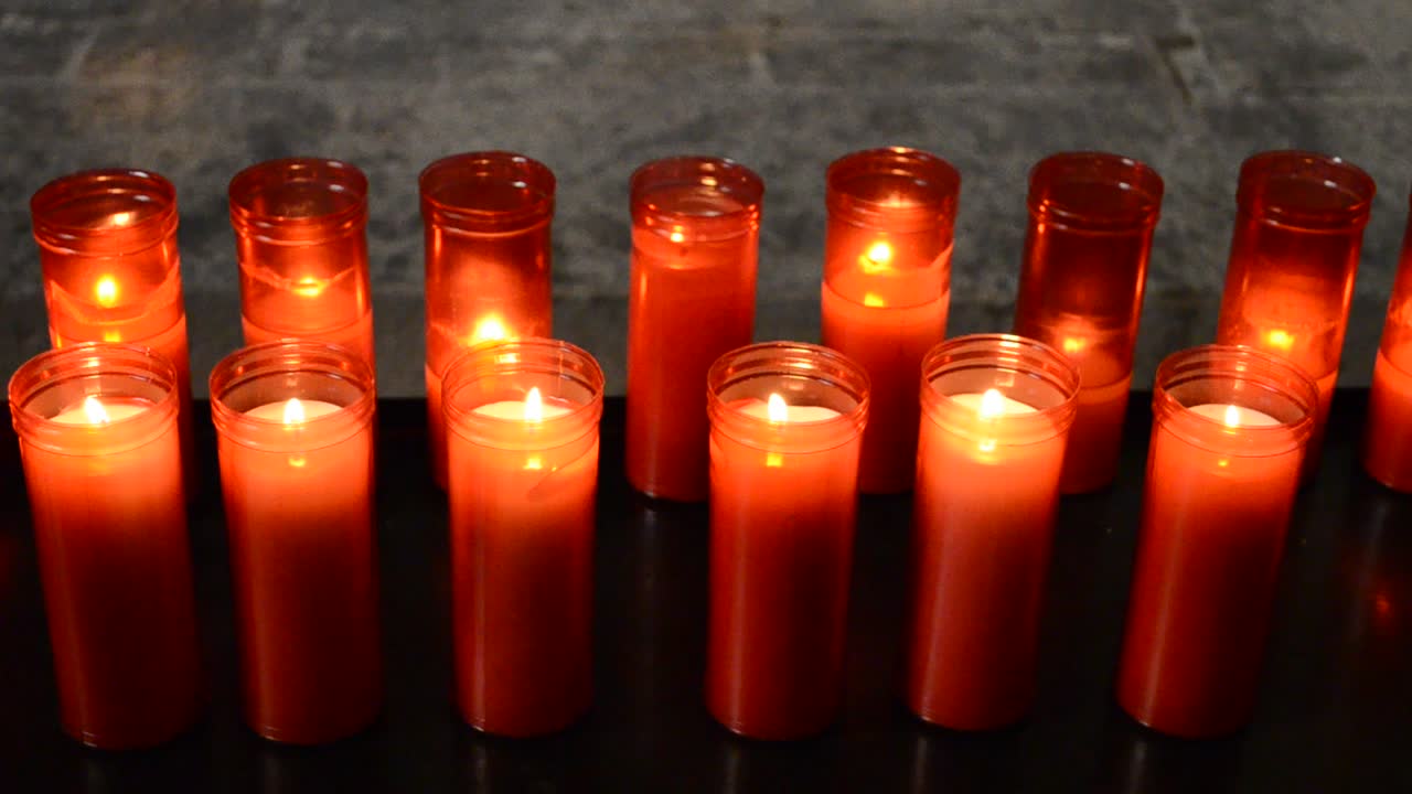 Candele da chiesa in lampadari trasparenti rossi e gialli