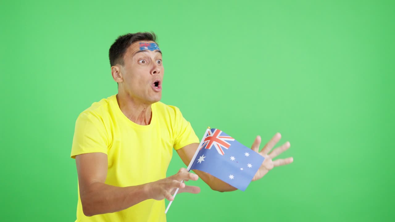 Man cheering for Australia waving a national flag looking away