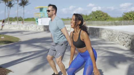 pareja haciendo ejercicio en el paseo marítimo