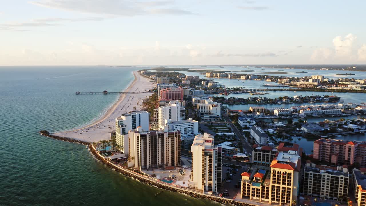 Clearwater Beach’s white sand shoreline stretches toward the pier, lined with resorts and framed by the Gulf of Mexico on one side and inland waterways on the other