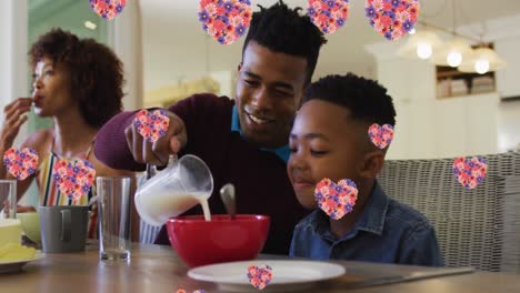 Animation-of-heart-icons-with-flowers-over-african-american-family-eating-breakfast