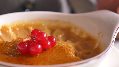 close up of a creme brulee with red currants