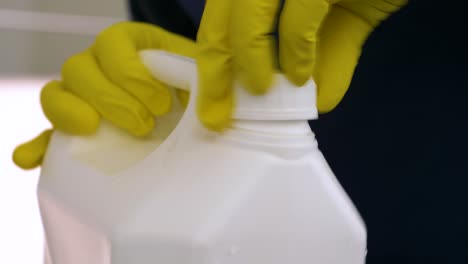 closing chemical jerrican with cleaning latex gloves, close up