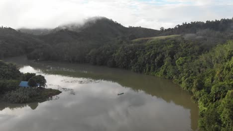 Drone,-longboat,-sampan-fishing-by-the-river-among-the-mountains-in-the-cloud-in-Sarawak,-Borneo