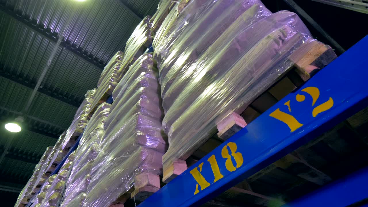 포장된 가방을 가진 많은 팔레트가 창고 랙에 있습니다. 창고 내부.