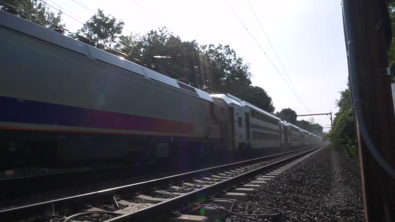 SLOW MOTION: Primo piano della parte anteriore di un treno pendolare mentre passa sui binari.