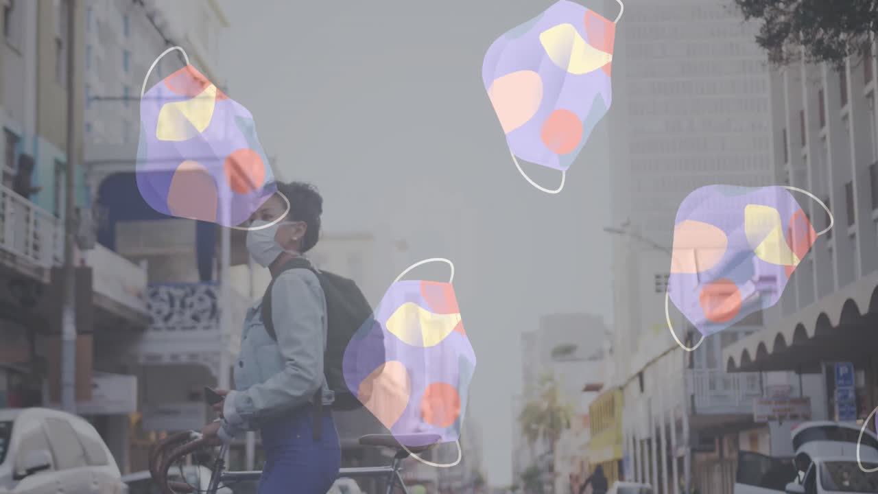 여러 개의 얼굴 마스크가 거리를 가로지르는 자전거와 함께 얼굴 마스크를 쓰고 있는 여성을 향해 움직이고 있습니다.