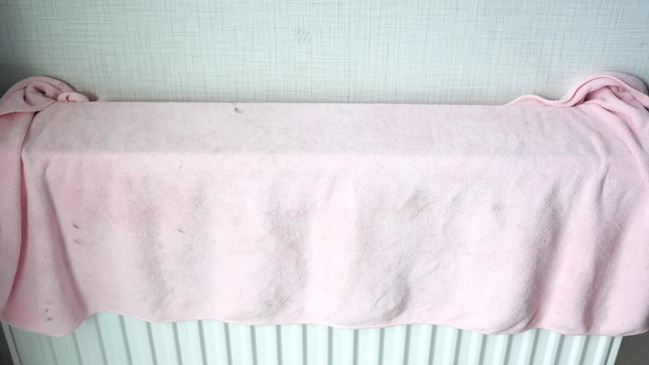 더러운 라디에이터를 는 분홍색 수건