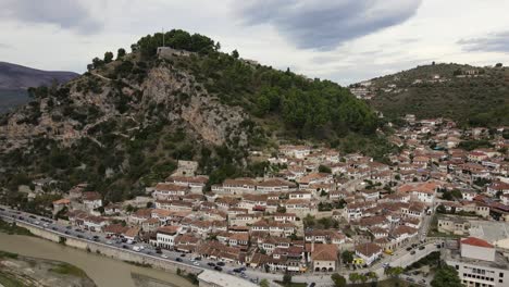 panoramic drone shot of old city of berat and osum river surrounded by mountains and hills, albania