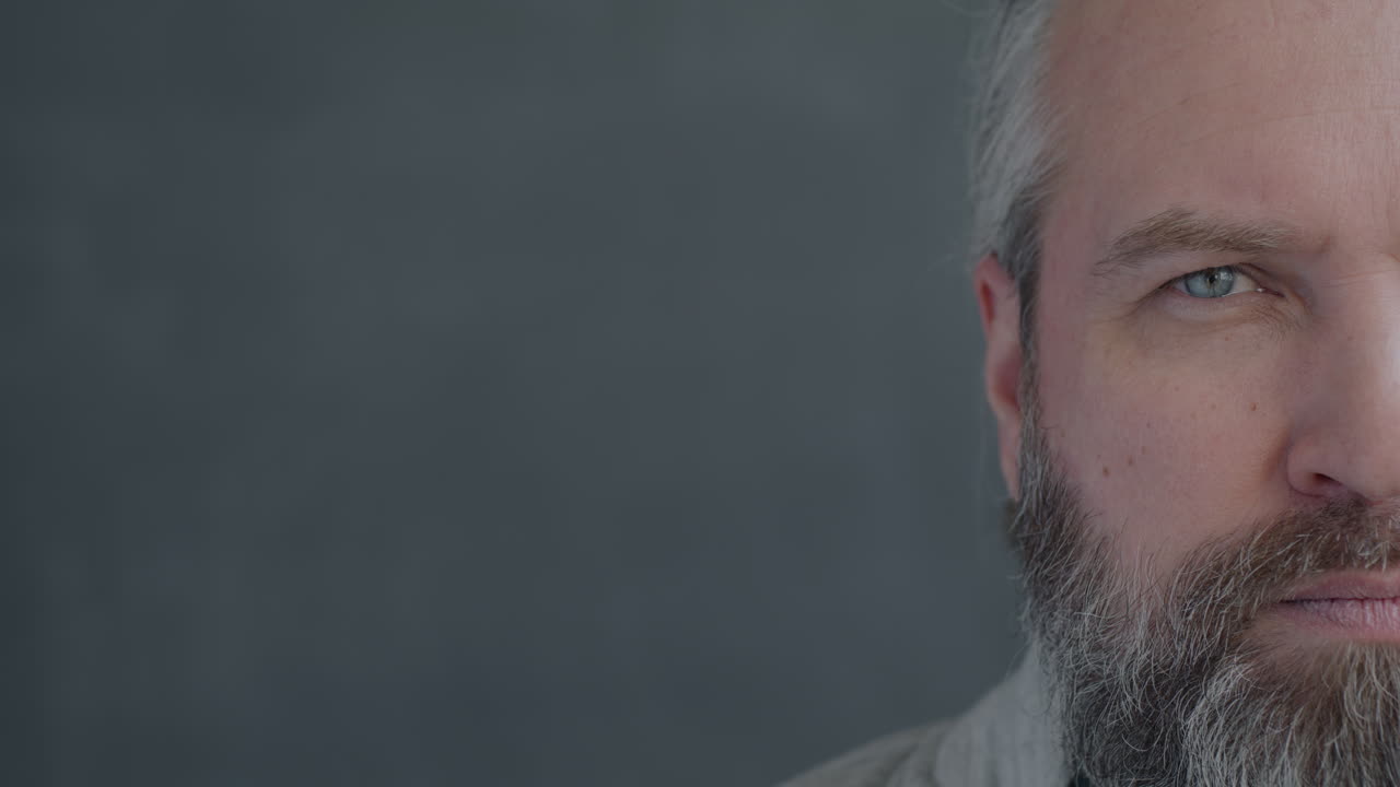 Close-up of a man with a beard and gray hair