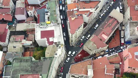 vista aérea de arriba hacia abajo de los coches en una bifurcación en la carretera rodeada de viejos y altos edificios residenciales europeos con techos naranjas en un día nublado en estambul, turquía