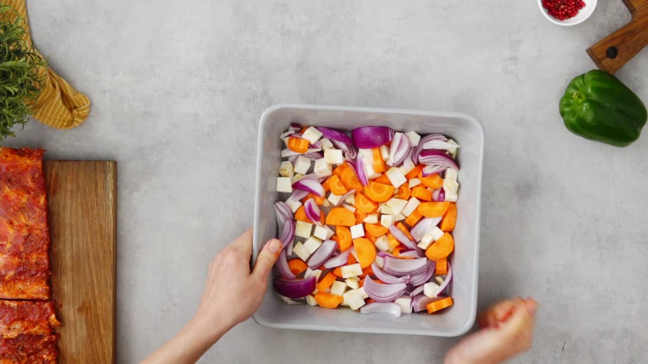 persona anónima organizando costillas crudas y verduras en la mesa