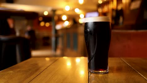 two pints of stout being picked up