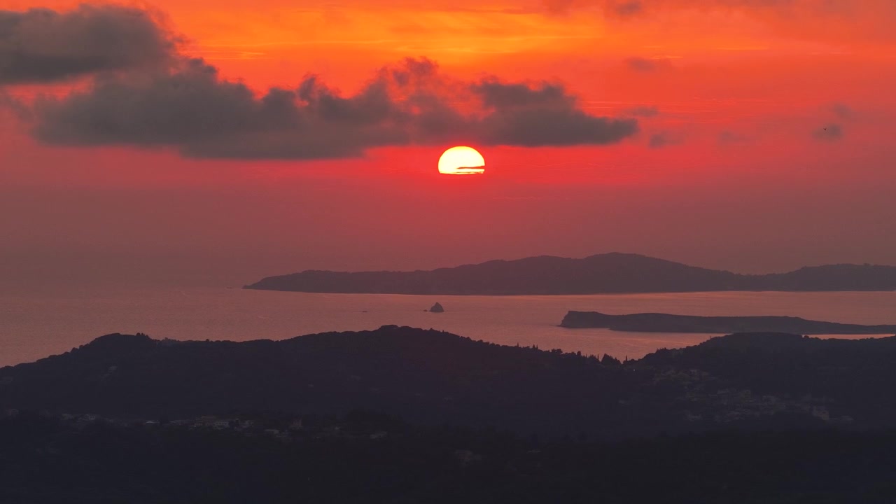 ギリシャ・北コルフの海と島影に沈むドラマチックな赤い夕日