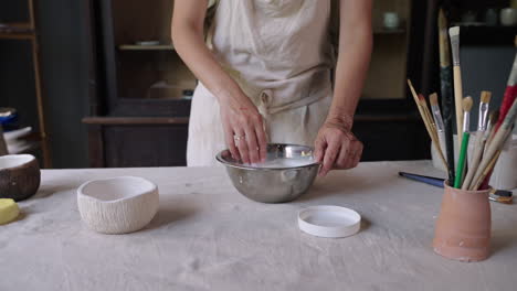 woman cleaning pottery tools