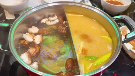 simmering hotpot with ingredients in divided sections