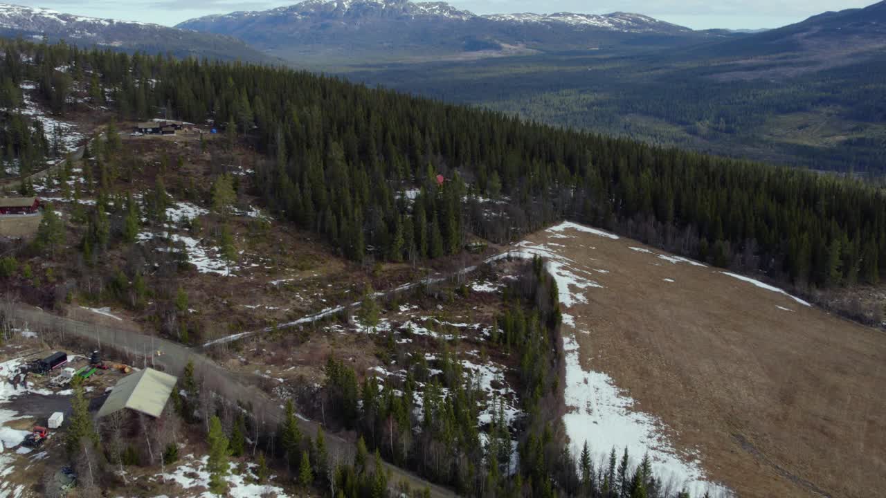 vista aérea sobre el bosque de las tierras altas con algo de nieve, primavera en la soleada uvdal, noruega - aumento, disparo de drones