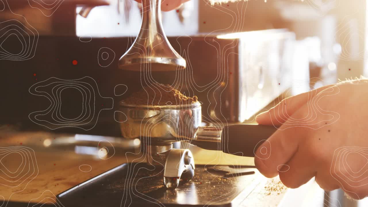 Barista's hand lifting scoop and dosing grounds into portafilter before tamping for extraction