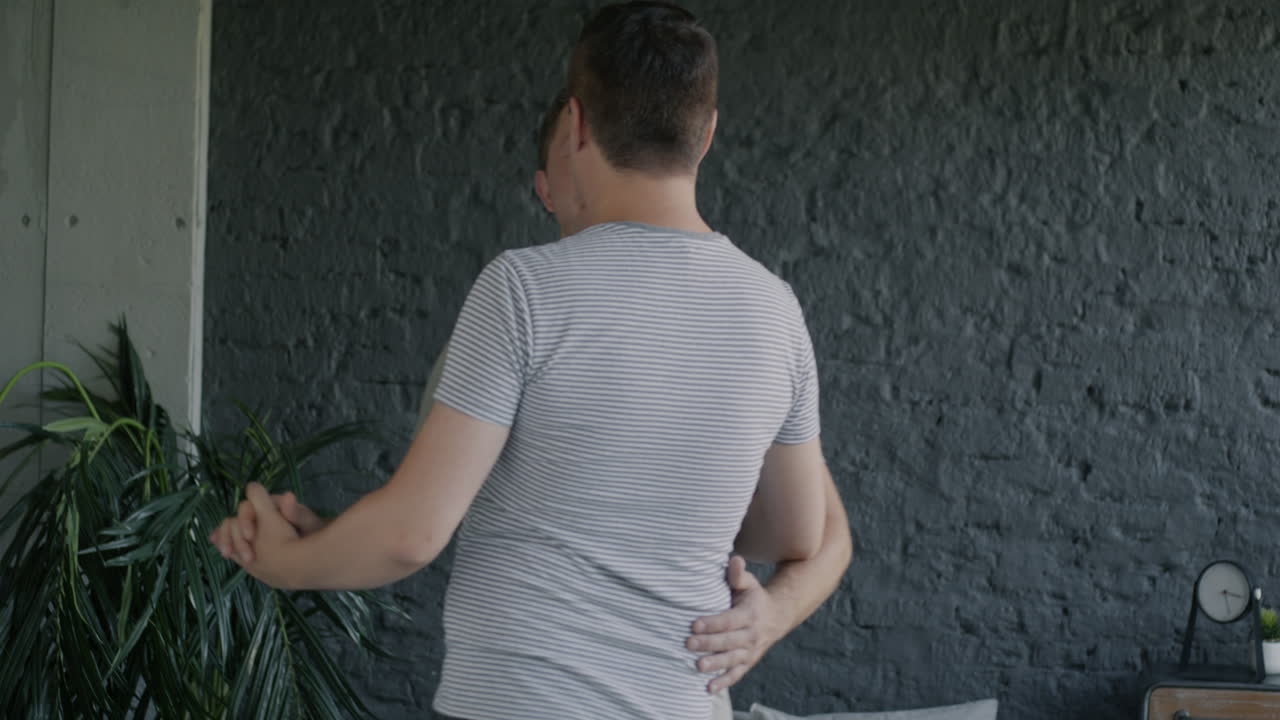 Two men dancing in their bedroom
