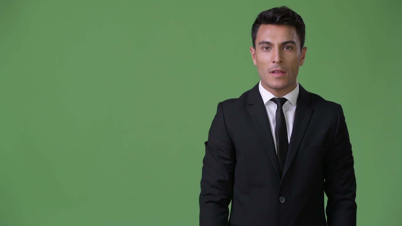 초록색 배경에 젊은 잘생긴 히스패닉 사업가