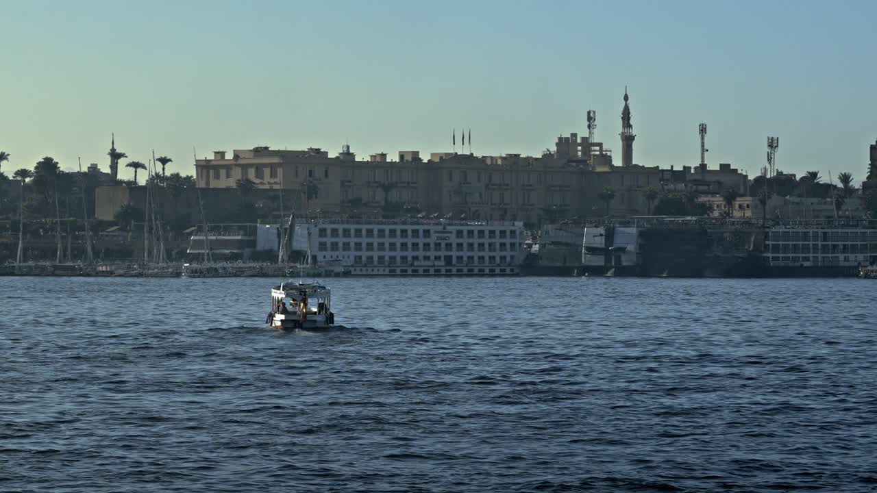 Una vista mozzafiato del fiume Nilo al tramonto a Luxor, Egitto. La scena cattura le acque tranquille che riflettono le calde sfumature dorate del sole al tramonto