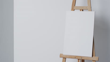 video of white canvas sign on wooden easel with copy space on white background