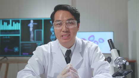 Asian Scientist Researching In The Laboratory With A Microscope And Speaking To The Camera