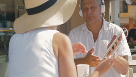 couple sitting in cafe and using gadgets