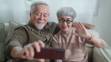 happiness heart warming old retired grand parent video calling conversation with their distance family together with careless and cheerful expression home interior background
