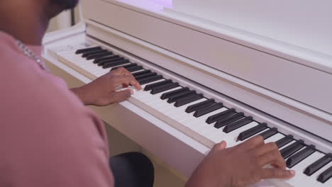 man playing a white digital piano