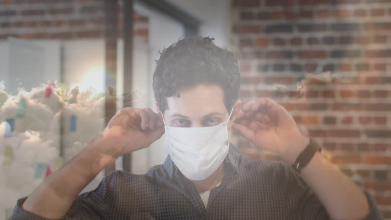 사무실에서 얼굴 마스크를 쓰고 있는 백인 남자를 상대로 하늘에 있는 구름의 디지털 복합 비디오