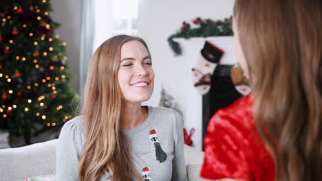 madre emocionada recibiendo un regalo de navidad de su hija en casa