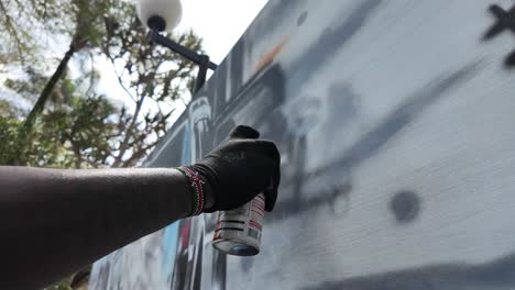 una mano de un artista rociando graffiti en acción