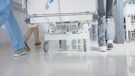 diverse doctor and surgeons walking with patient on hospital bed in slow motion