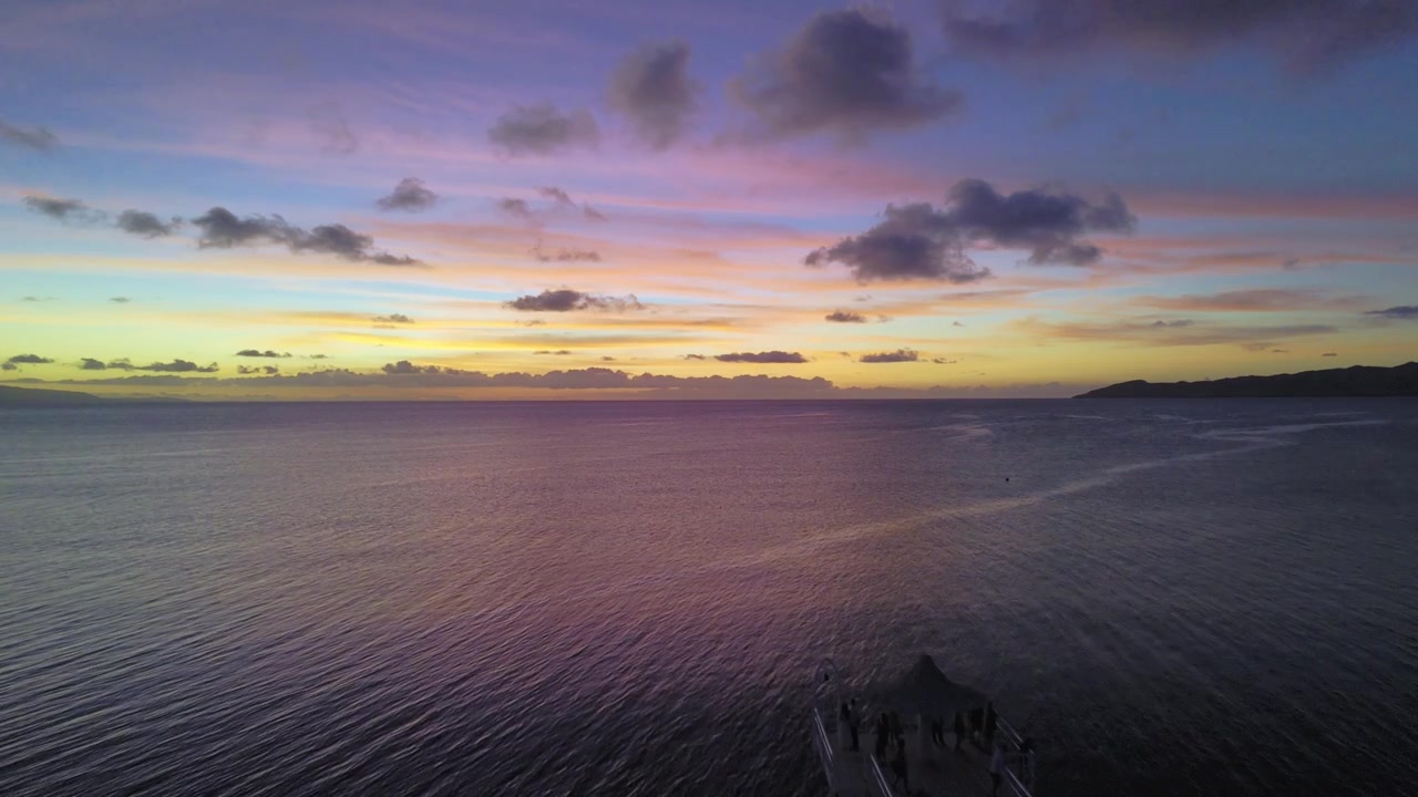 Immagine aerea nitida dell'orizzonte colorato dove il cielo viola incontra le calme acque del Pacifico