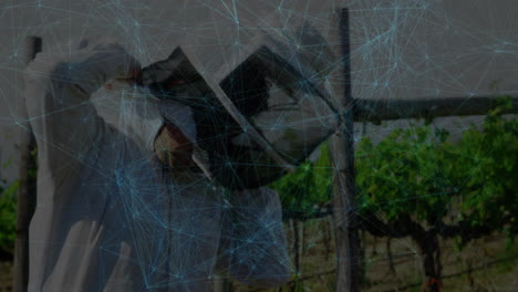 mid-adult man hanging laundry on clothesline in rural vineyard, with tech overlay mapping flow