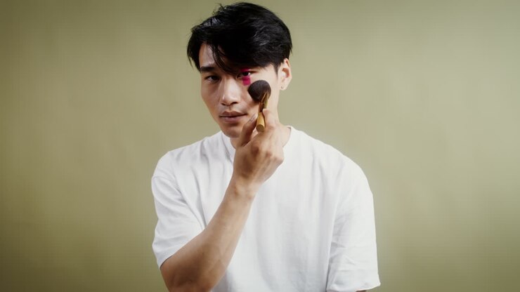 Uomo che applica il make-up con un pennello