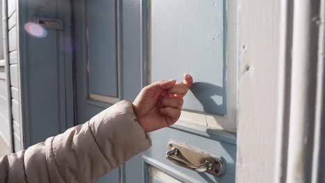una mujer llamando a una puerta.