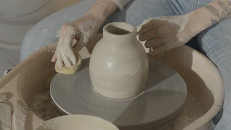 a female ceramicist cleaning the pottery wheel