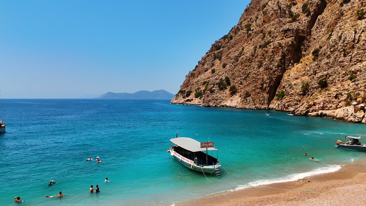 Quick rise over the striking azure waterscape near the unapproachable rocks. Not many people swim in the water near the boat