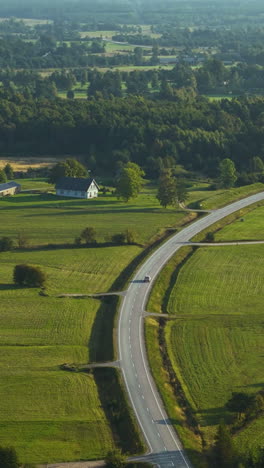 aerial view of a car traveling on the scenic p111 highway on the western coast of latvia, cruising along the baltic sea coast from strante to ulmale.
