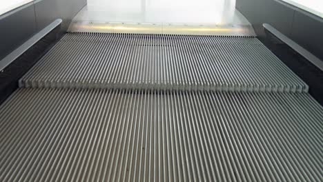 an escalator going up and arriving at the top