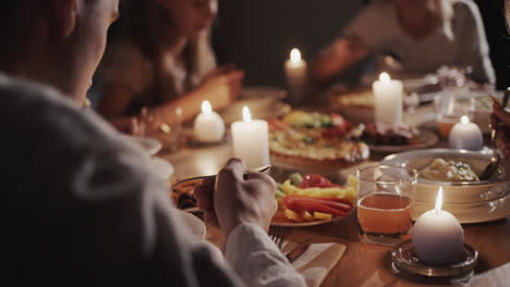 una gran familia amigable come en la mesa festiva a la luz de las velas