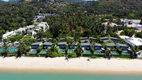 Aerial-view-of-luxury-tropical-villas-with-pools-by-the-sand-beach-on-a-tropical-island-in-Thailand