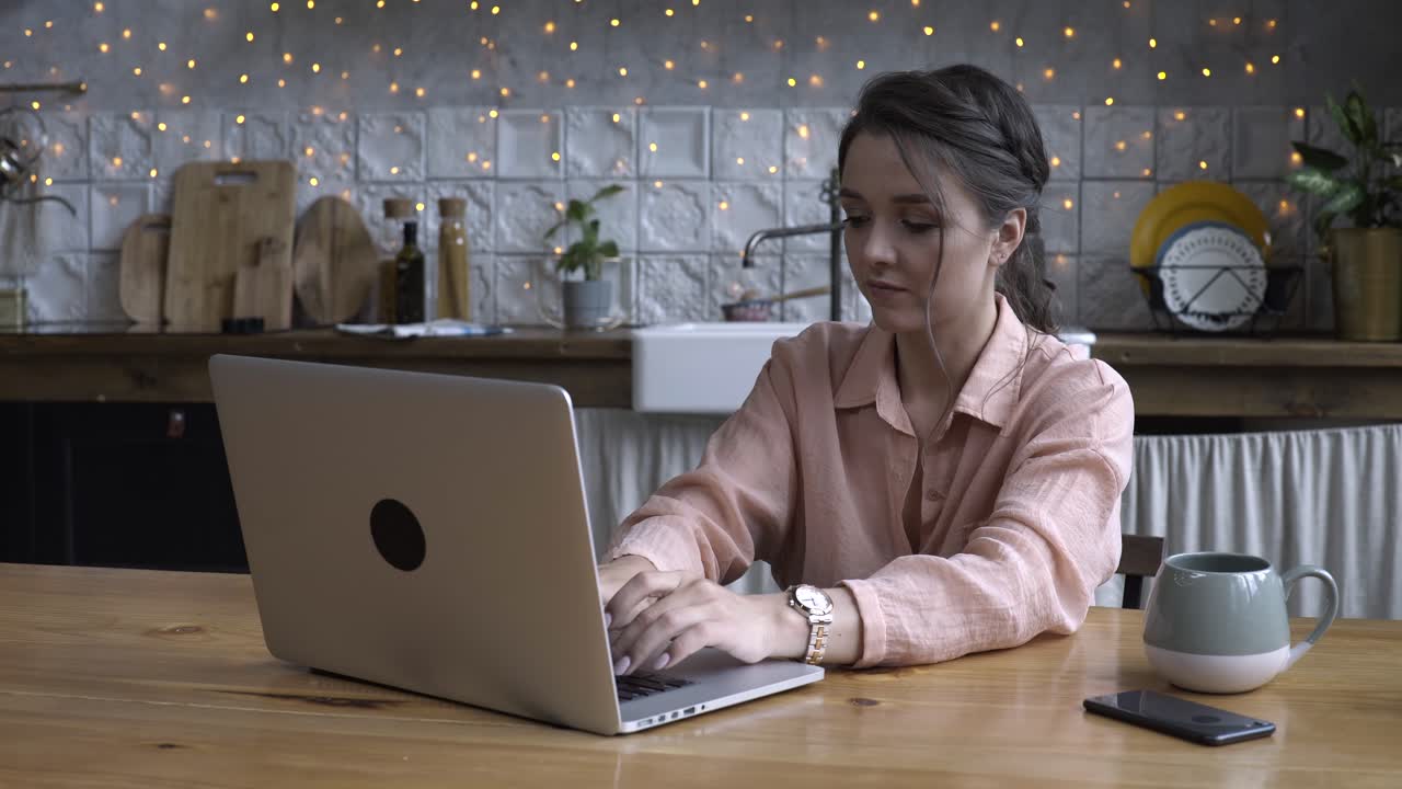mujer trabajando en una computadora portátil en la cocina