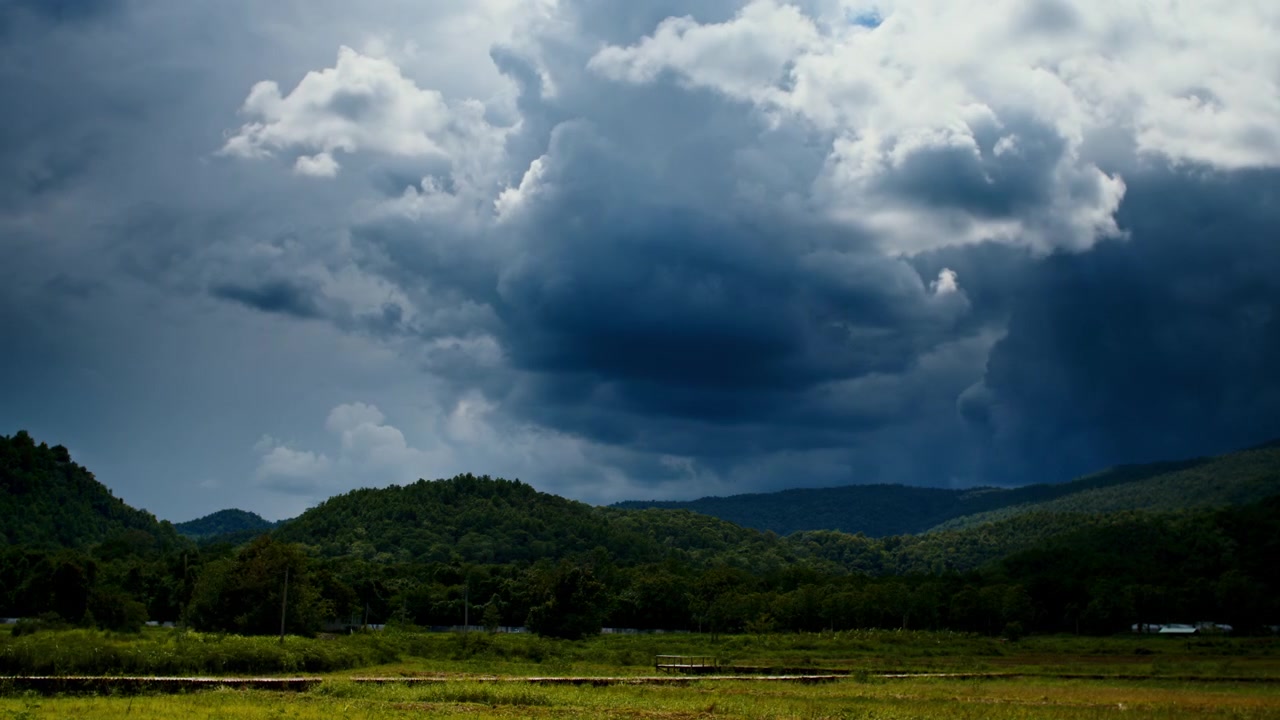 Awan Badai Gelap Bergerak Melintasi Pegunungan Hijau Subur.