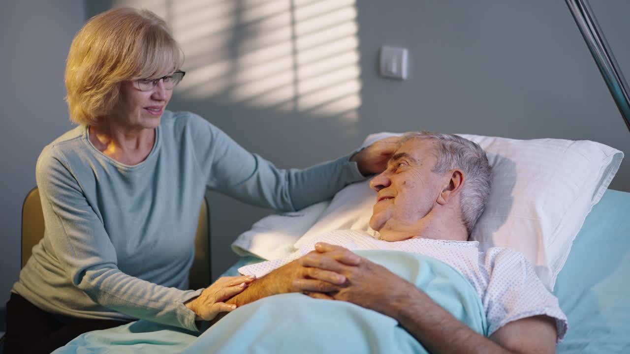 Elderly patient in hospital with caring woman
