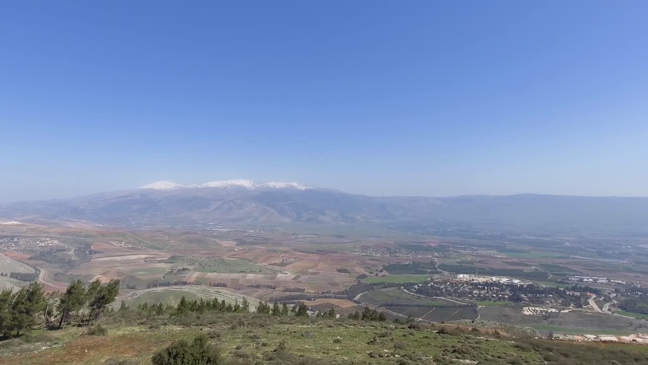 enorme valle con un pueblo al fondo expuesto y la montaña hermon al fondo